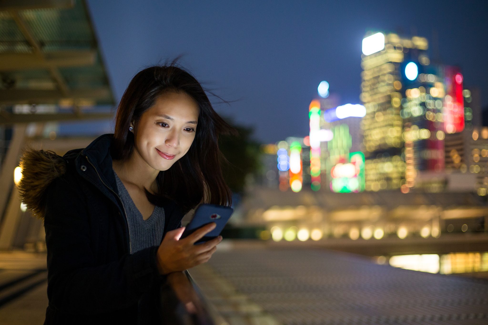 Woman look at phone at night - GuardMetrics